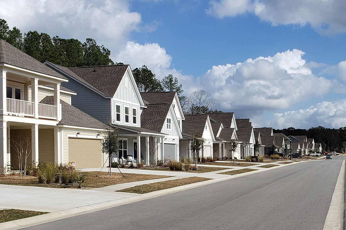 Street view of a new-construction neighborhood with a row of homes Street view of a new-construction neighborhood with a row of homes